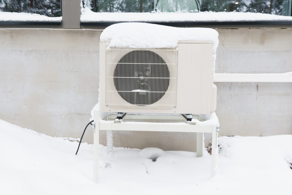 The outdoor unit of an air-source heat pump after a winter storm.