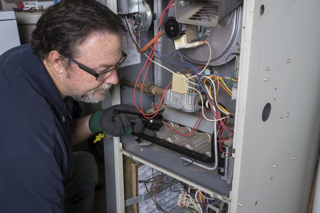 Technician looking over gas furnace